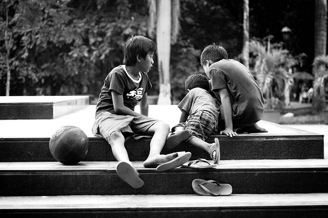 Boys sitting on park stairs together.