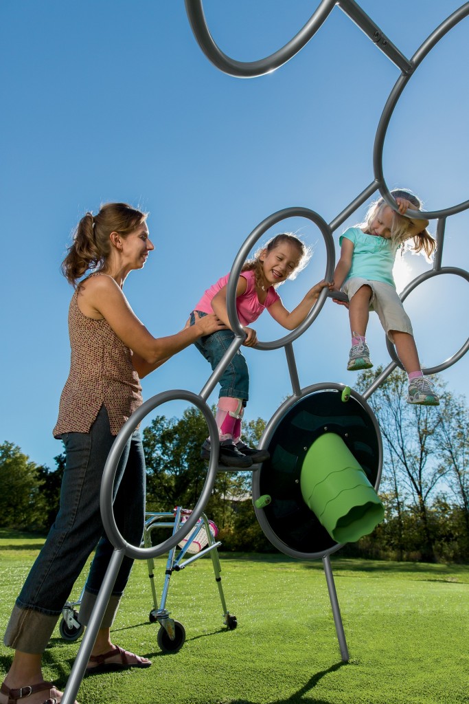 Photo - Child playing on Unity Dome with help from caregiver