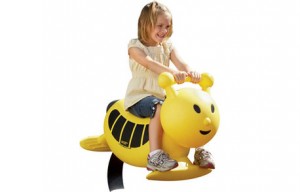 Little girl riding a bumble bee playground spring rider