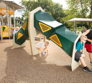 Kids climbing through a tunnel on a playground