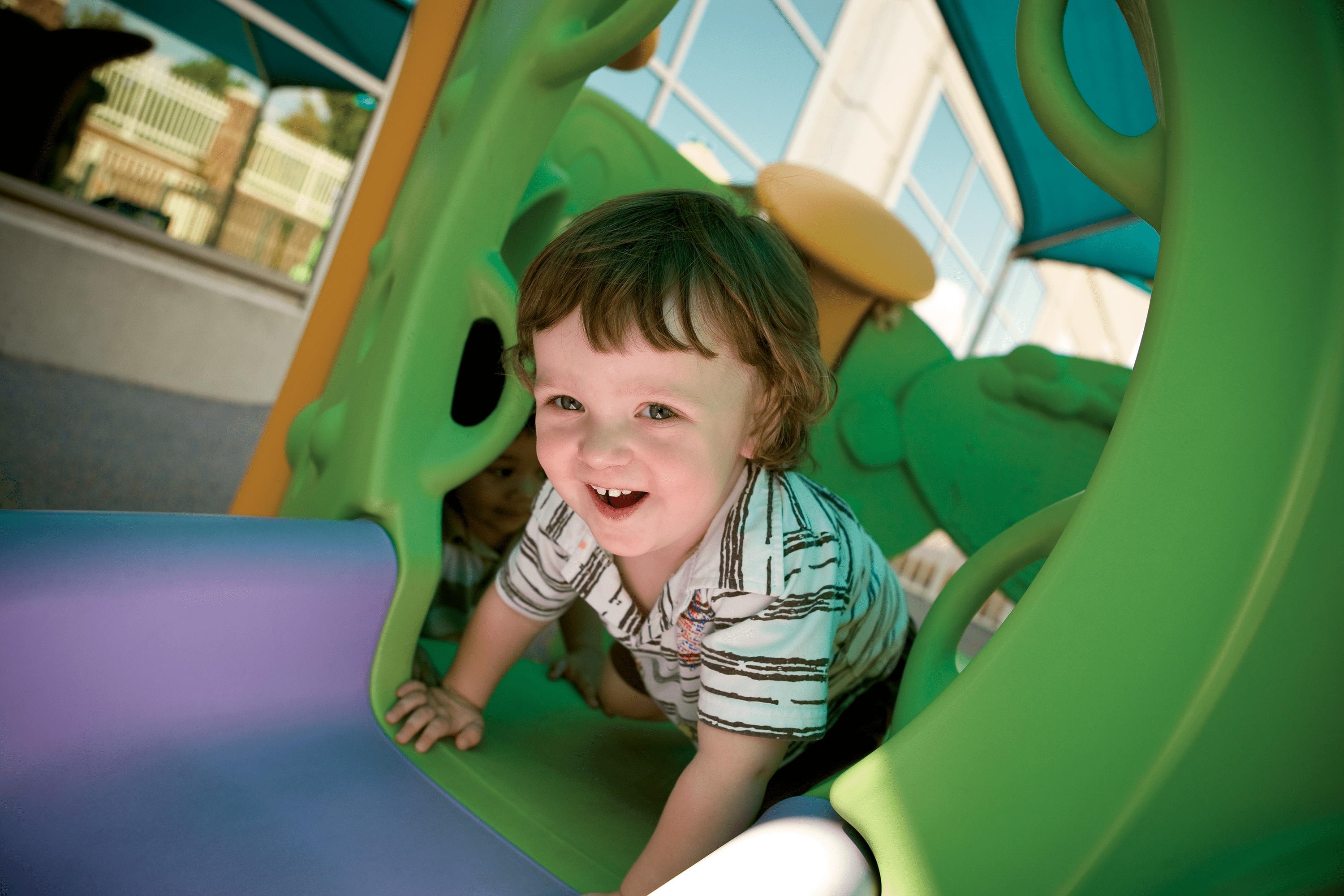 A smiling toddler playing on a playground