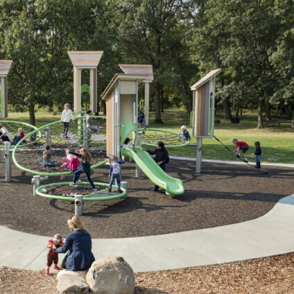Kids climbing on a net structure while adults supervise