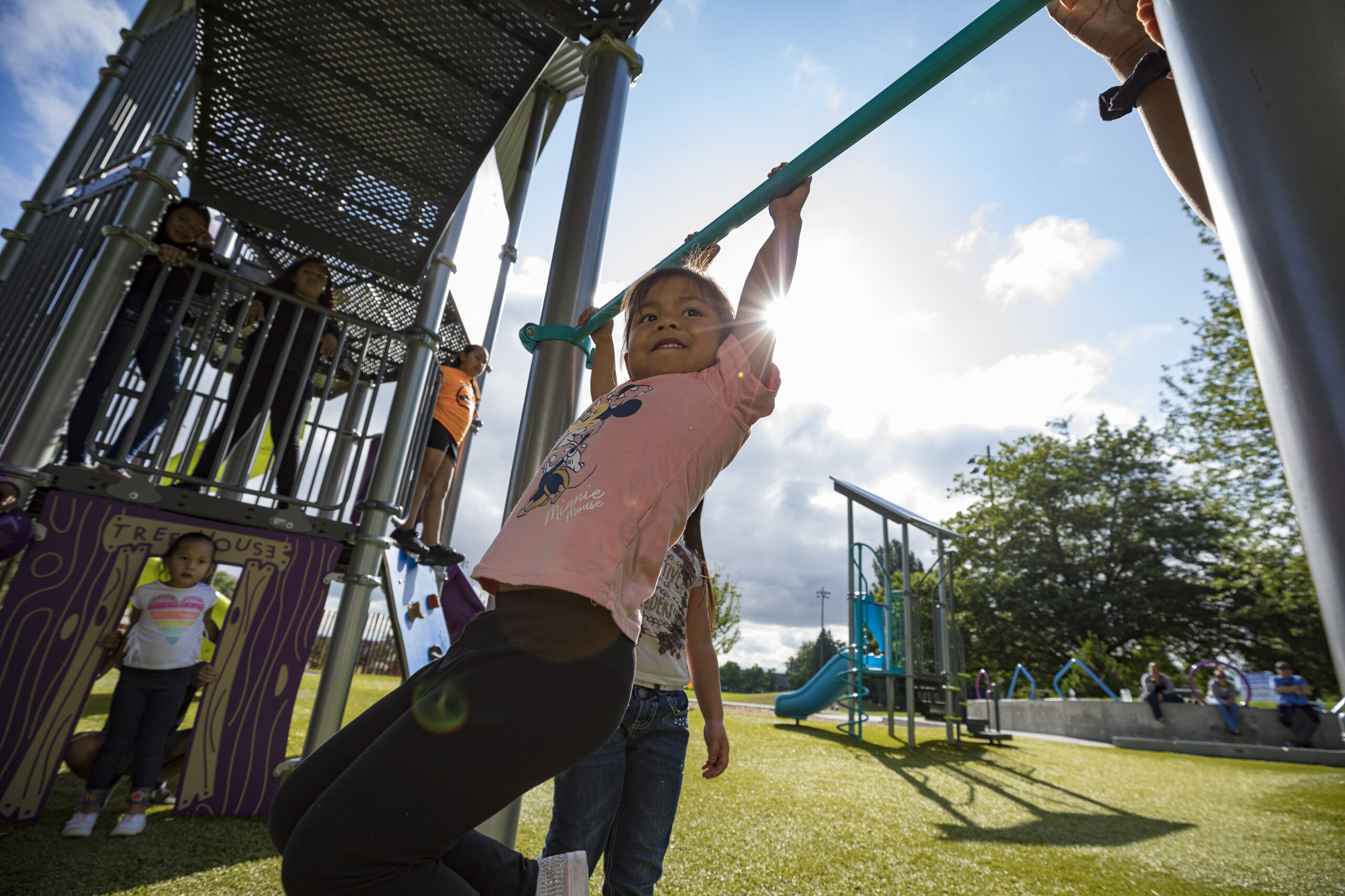 Kid swinging from a chinning bar