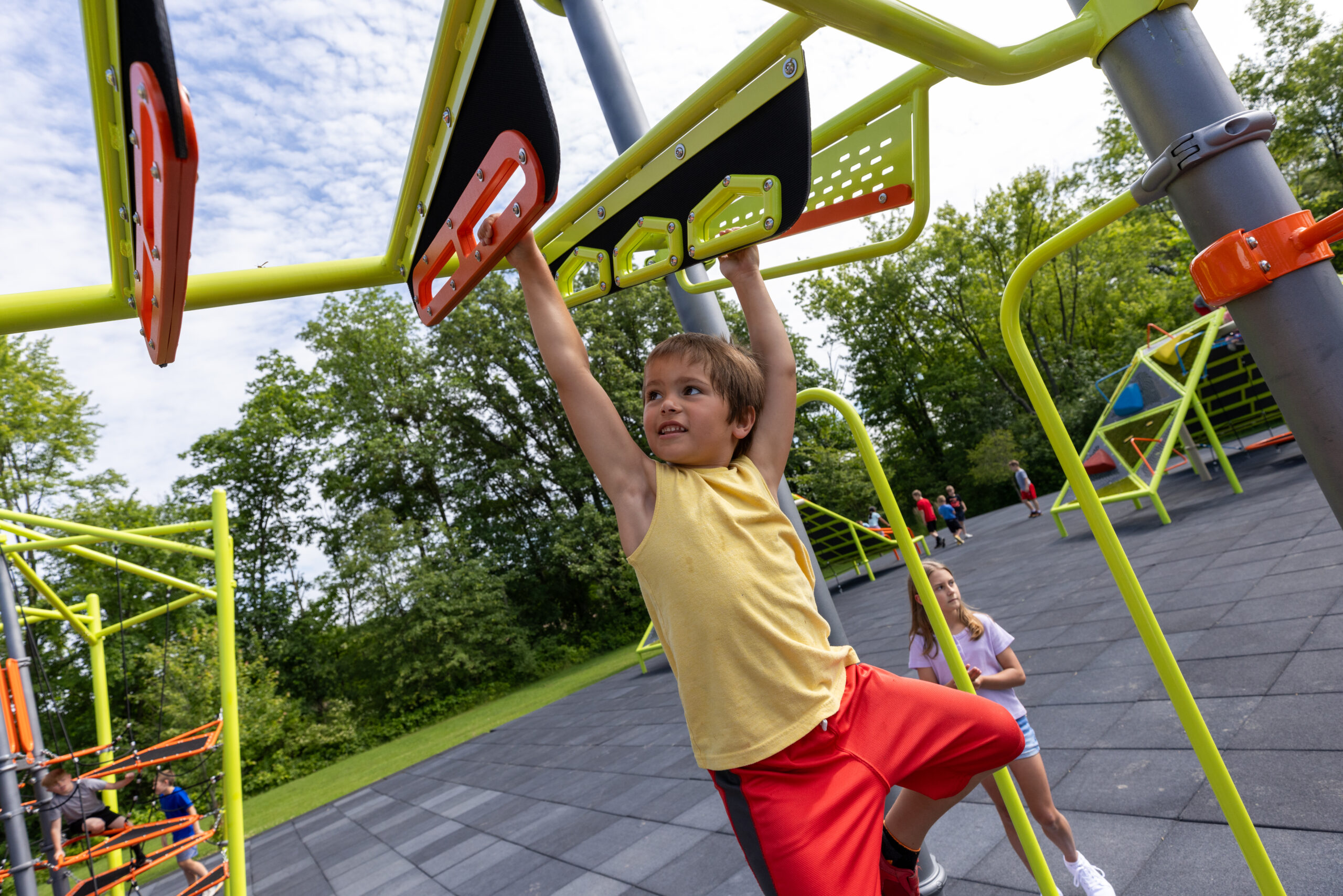 A kid building upper body strength while playing on a playground