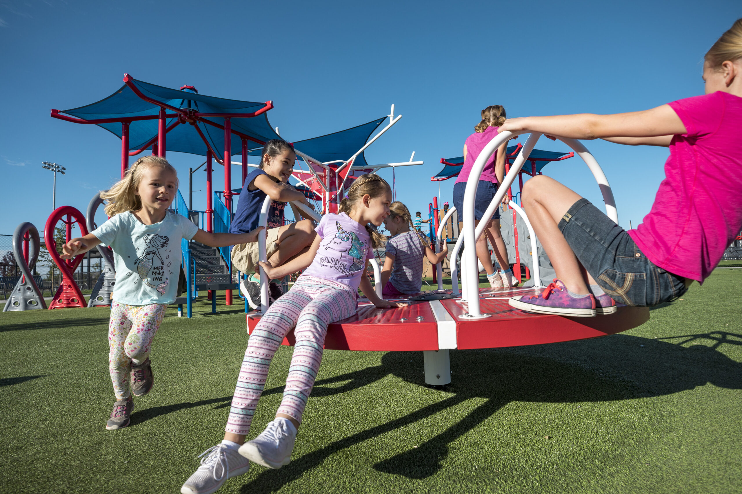 Kids playing on a spinner on the playground
