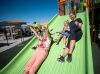 Two adults and two children sliding down the Mighty Descent slide together