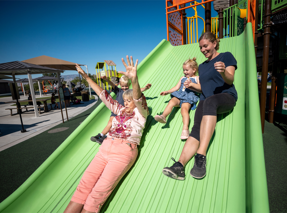 Two adults and two children sliding down the Mighty Descent slide together